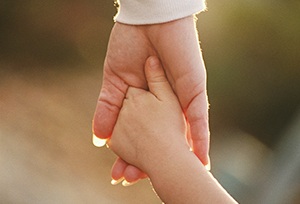 Child holding hands with adult - sunlight on hands only_resized